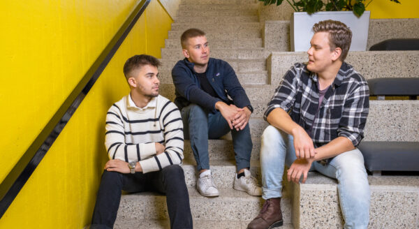 Kolme nuorta miestä juttelemassa.