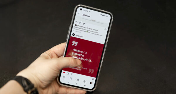 Kädessä älypuhelin, jossa näkyy inspisvinkki.